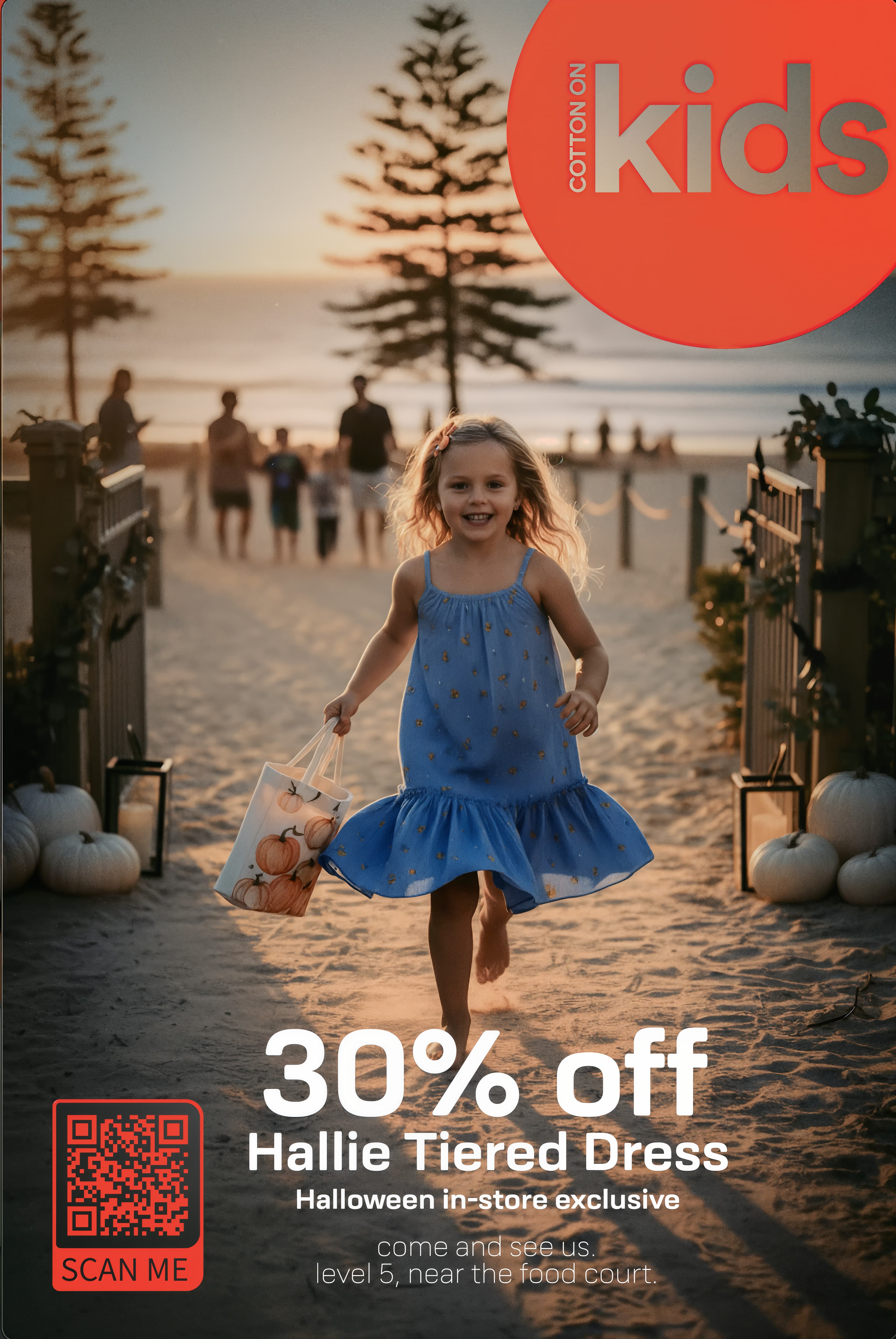 Cotton On Kids promo: girl in a blue tiered dress running a beach path at sunset