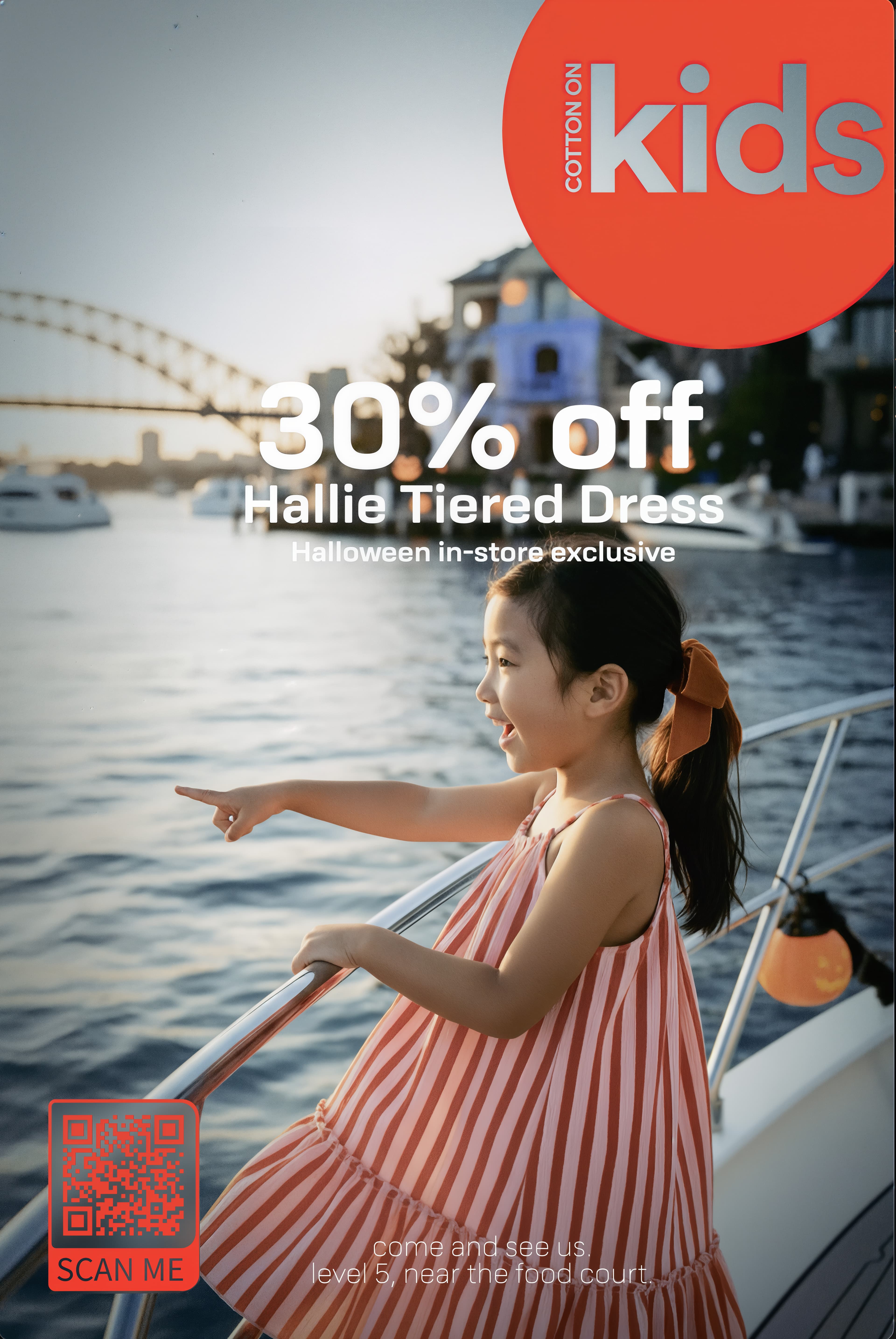 Cotton On Kids promo: girl in a red striped dress pointing from a boat, harbour bridge behind