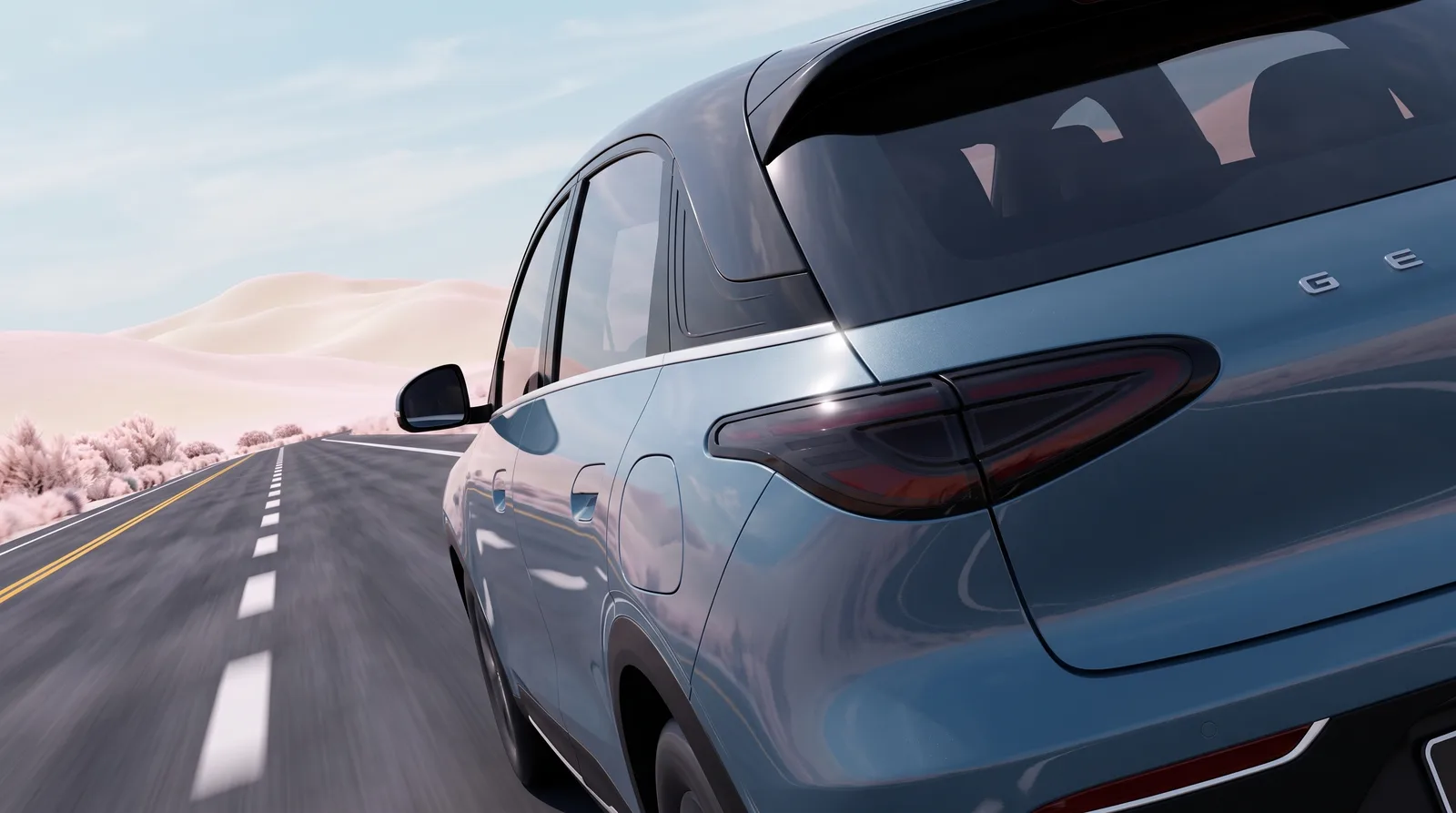 Rear quarter of a steel-blue SUV on a desert dune road