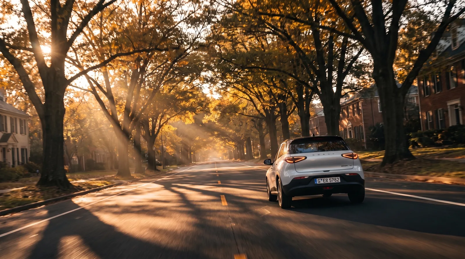 White SUV on an autumn suburban street at golden hour